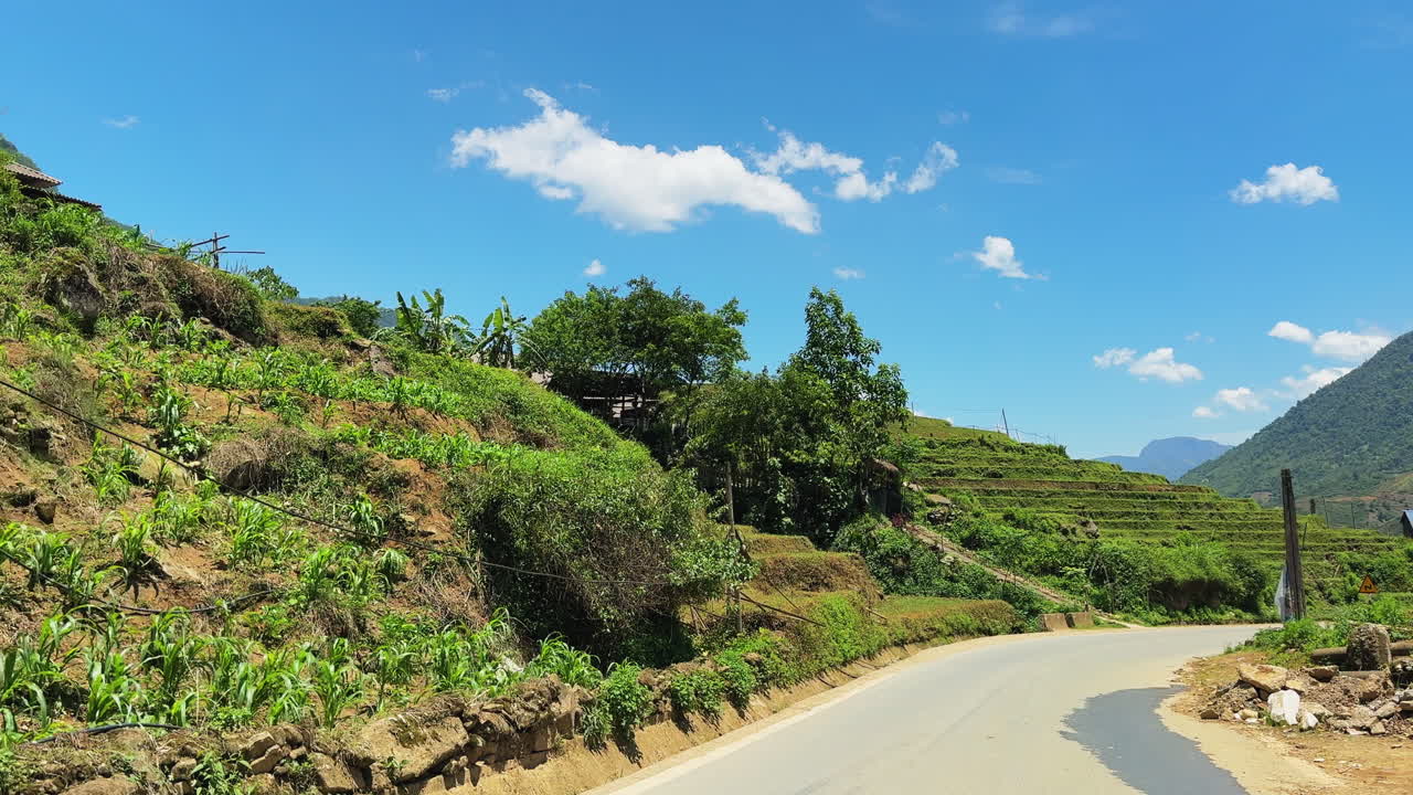 Clip of driving on a street with lush greenery and blue sky in Sa Pa, Vietnam