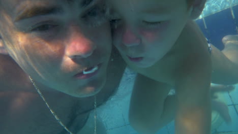 Padre-E-Hijo-Buceando-Juntos-En-La-Piscina