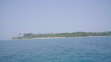 Sailing-past-the-peninsula-of-a-remote-island-with-azure-blue-sea-white-sand-and-trees-up-to-the-sand-edge-with-no-houses-or-signs-of-development-in-the-andaman-island-chain