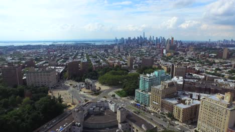 Vista-Aérea-Del-Horizonte-De-Manhattan-Sobrevolando-El-Tráfico-Del-Círculo-De-La-Plaza-Del-Gran-Ejército-4k