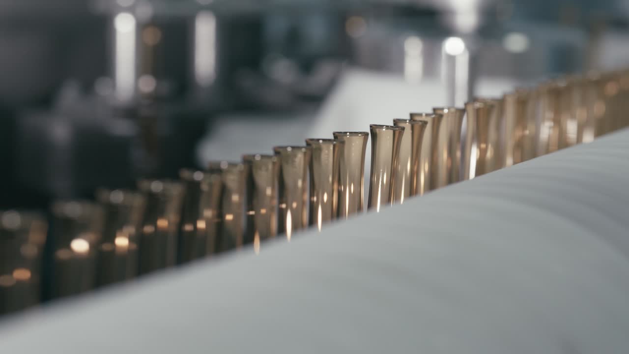 Rotating serum bottle on a conveyor machine in a modern pharmaceutical manufacturing plant