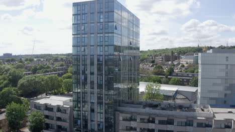 city aerial descent: shiny glass apartment building in london, england