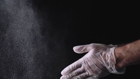 hands in gloves throwing powder