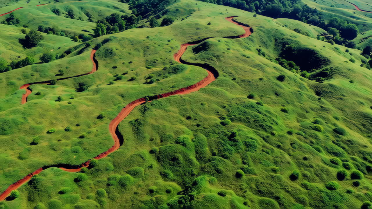 Red Dirt Road Winding Through Lush Green Hills