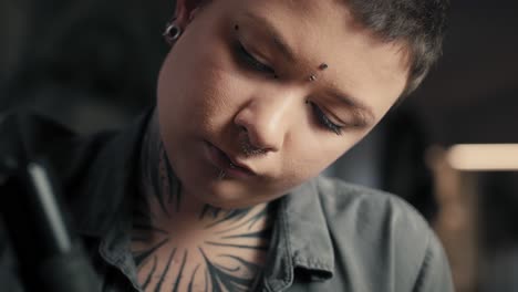 thoughtful woman tattooing arms of her customer.