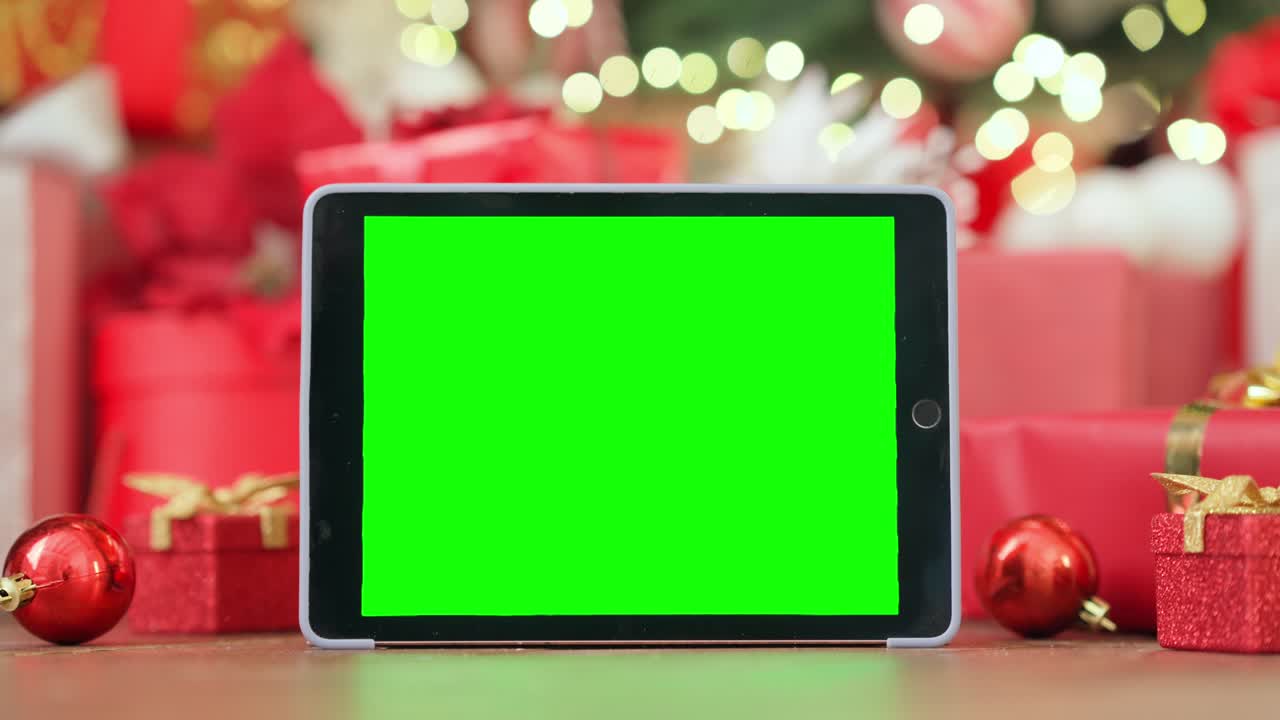 Digital tablet mockup green blank screen for ads on Christmas table background.