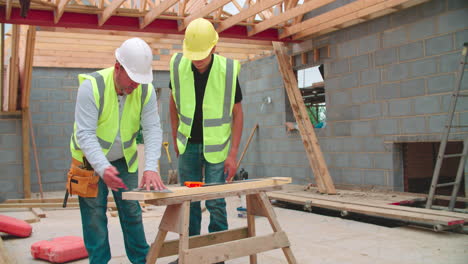 Tischler-Mit-Männlichem-Lehrling,-Der-Holz-Misst-Und-Schneidet