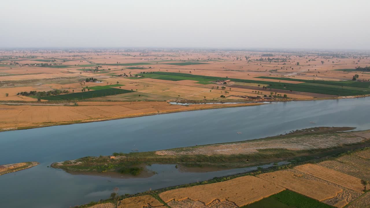 Wheat farms and lush fields divided by river in rural Punjab