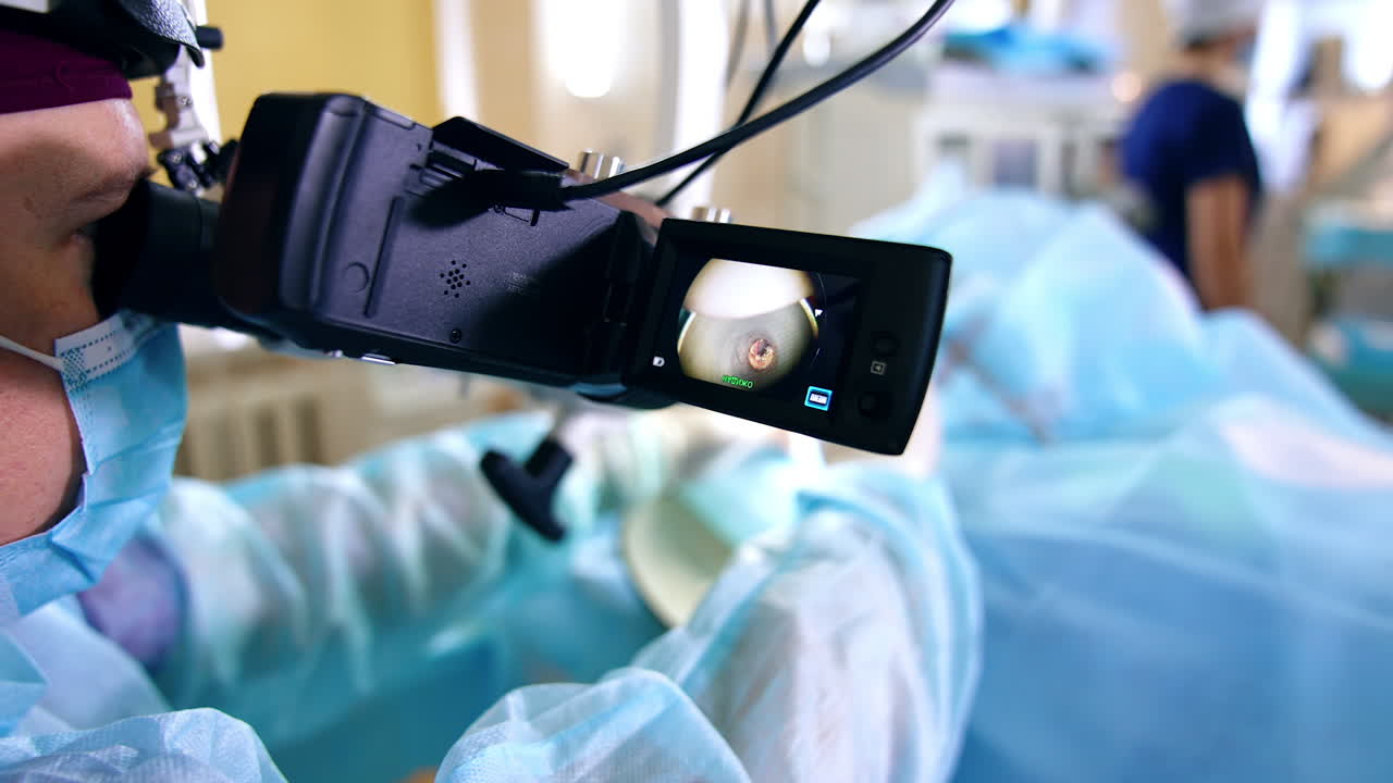Doctor is using microscope and video recording equipment at work. Medical procedure close up.