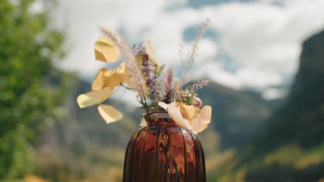 slow motion flower display flowing in the wind with mountains in the background