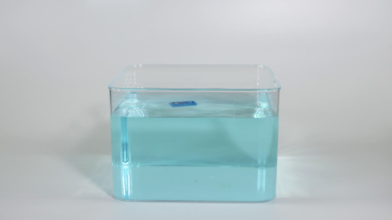 dejar caer bloques azules en un recipiente lleno de agua