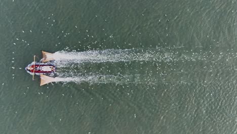 Drone-topdown-shot-of-a-Fishers-boat-dragging-the-nets-thru-the-water