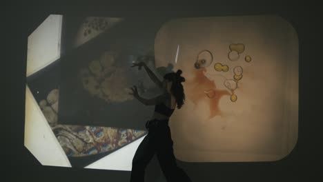 woman narrates a story through dance and gestures, while others change the scenery, creating incredible effects with a projector