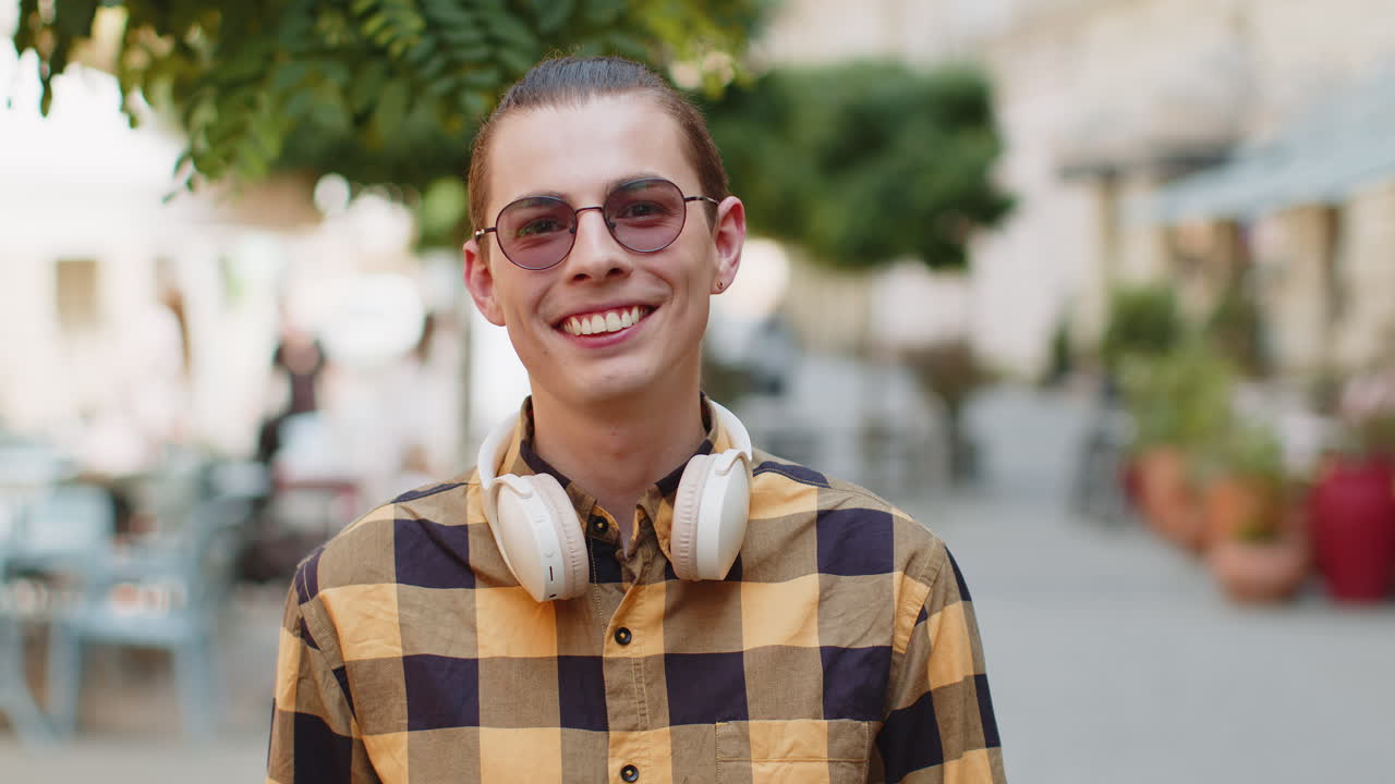 retrato de un hombre feliz con auriculares alrededor del cuello sonriendo amigable expresión de alegría mirando a la cámara