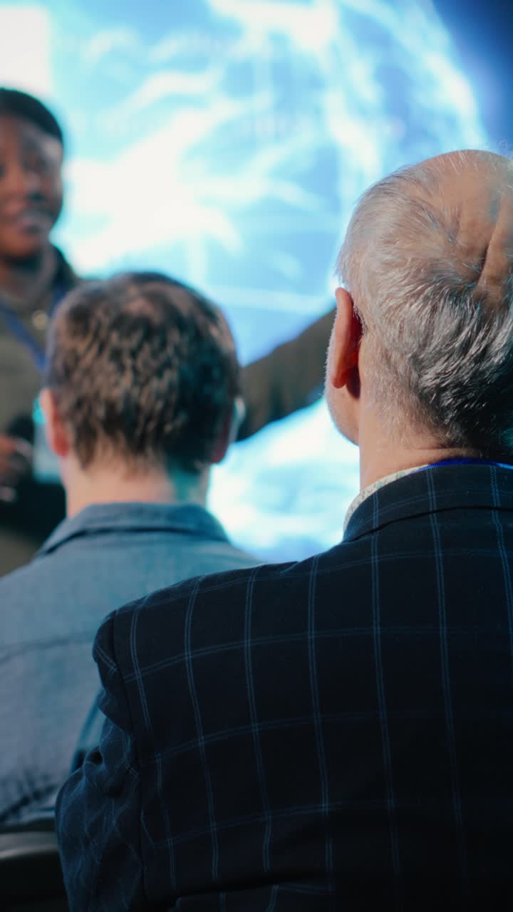 Video verticale: investitore senior ascolta l'oratore che presenta l'IA cerebrale high-tech
