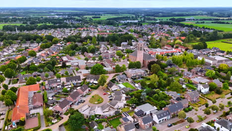 Drone view of Dutch village with church tower. A scenic aerial photo of a Dutch village featuring a central church tower and a mix of houses and greenery