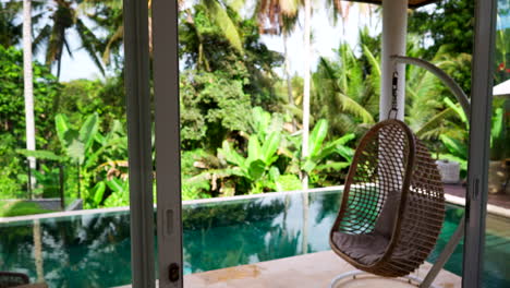 outdoor wicker hammock on the poolside of a villa in ubud, bali indonesia