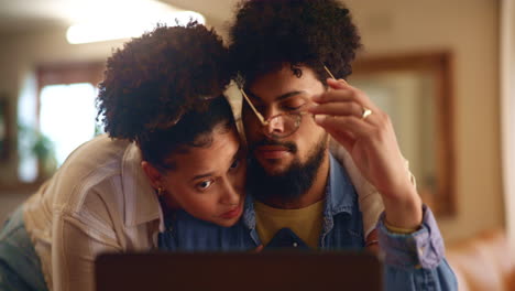 pareja abrazándose y mirando la computadora portátil