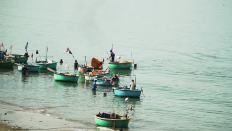 vietnamese coracle boats come to shore to unload their fish