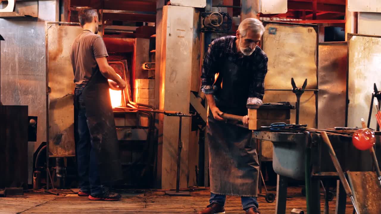 soplador de vidrio que da forma a un vidrio fundido