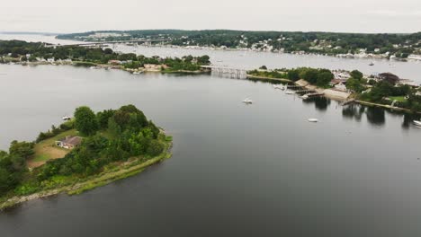 Aerial-view-of-coastal-town-with-sail-boats-and-vessels-over-private-island-in-New-England