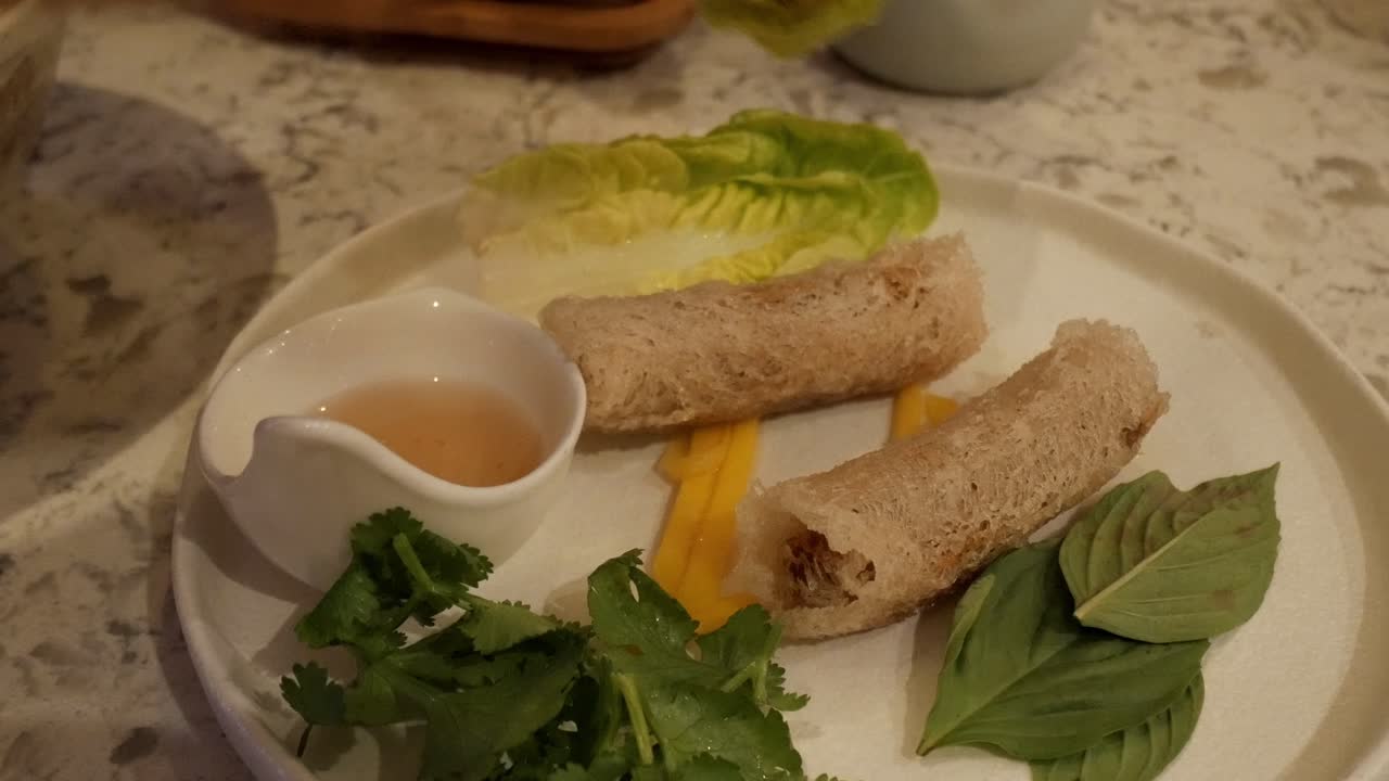 Crispy Vietnamese Nem Ran (Cha Gio) rolls with herbs, lettuce, and dipping sauce