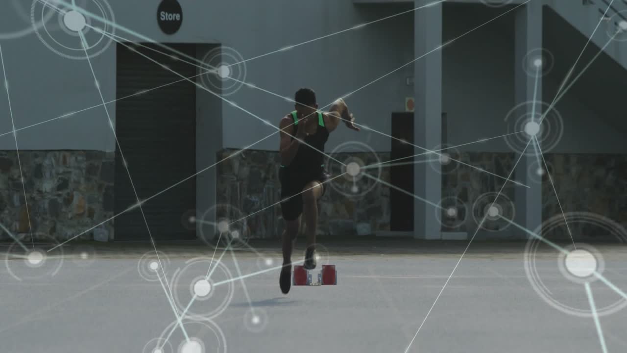 Male sprinter pushing off red starting blocks upon start signal, animating technology data network