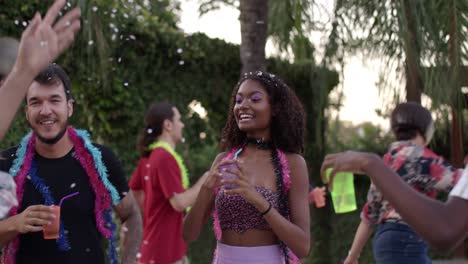 diverse friends celebrate carnival with dancing and drinks outdoors