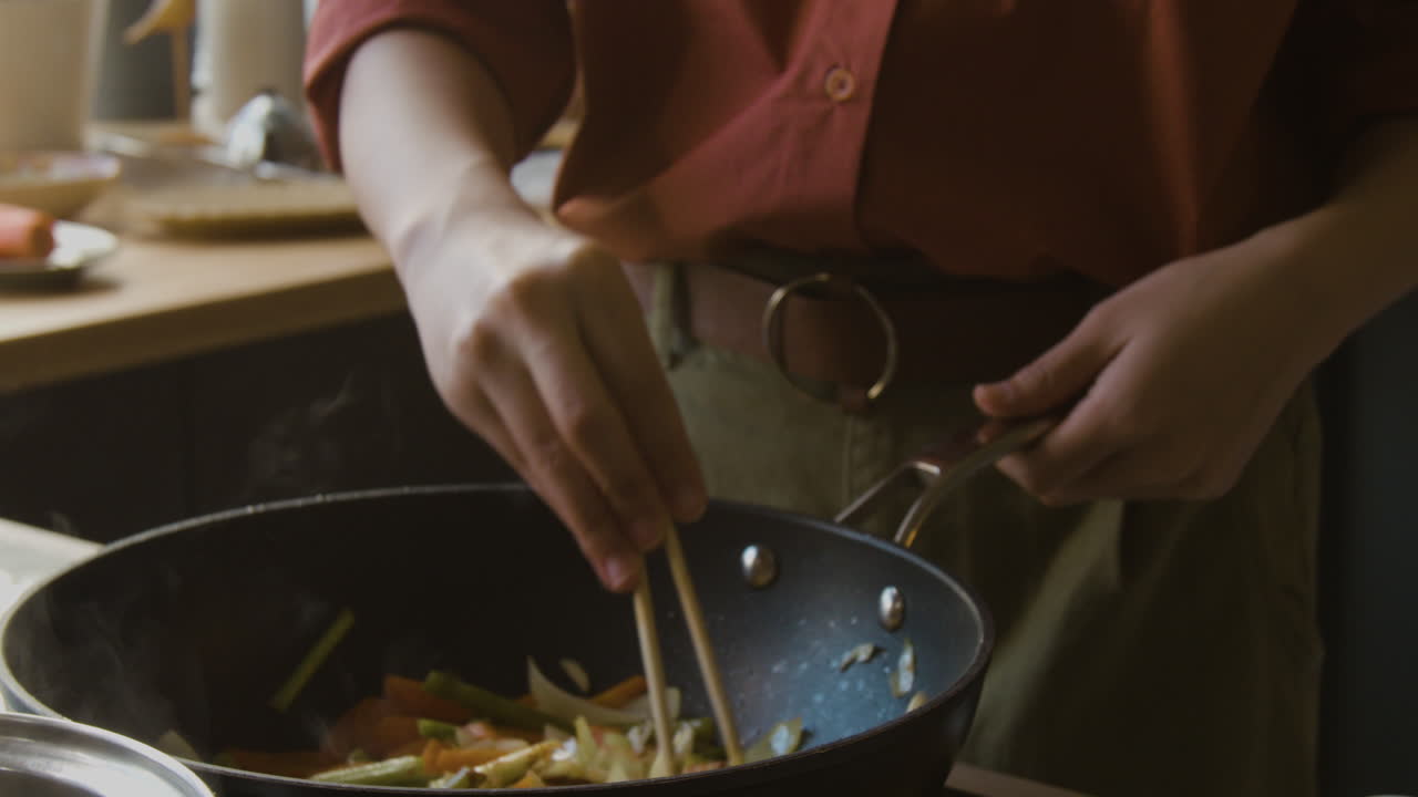 Woman Cooking Stir-fried Vegetables in a Wok
