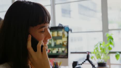 Diseñadora-Gráfica-Femenina-Hablando-Por-Teléfono-Móvil-En-Una-Oficina-Moderna-4k