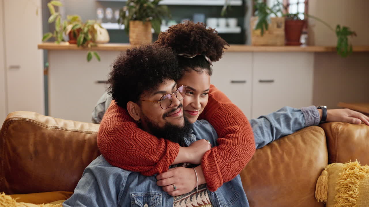 pareja abrazándose en un sofá en una sala de estar