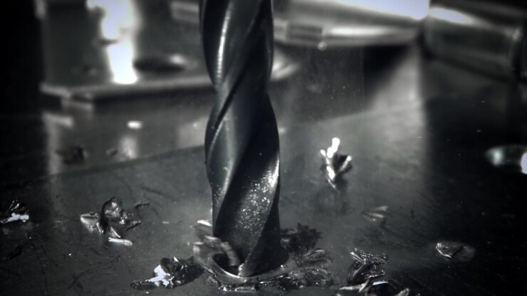 Slow Motion Close-up of a Drill Bit Making a Hole in Metal