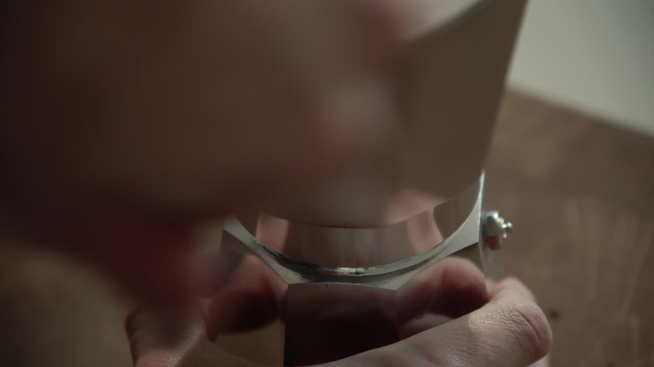 Fechando a cafeteira Bialetti Moka Express pela manhã na cozinha de casa