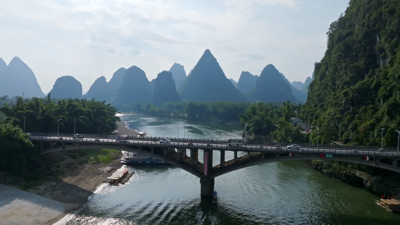 Aerial tracking shot of traffic on the Yangshuo bridge, in sunny Guangxi, China