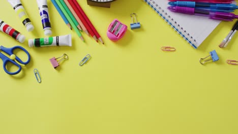 video de suministros escolares y cuadernos, clips de papel, bolígrafos sobre fondo amarillo