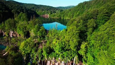 Set-of-waterfalls-flowing-from-big-dark-water-lake-surrounded-by-green-forest-in-Croatia