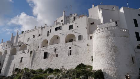 panning shot of ostuni city white walls and its fortification in italy at sunset