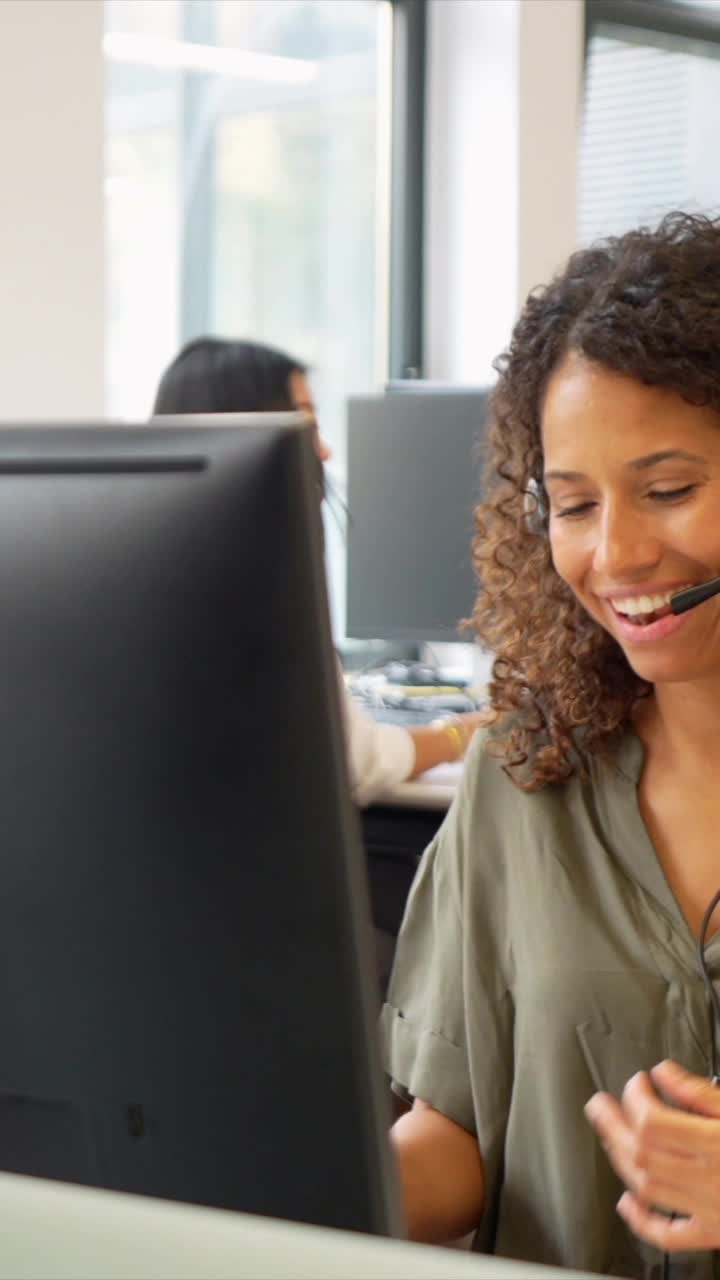 Donna con cuffie che lavora al computer in ufficio