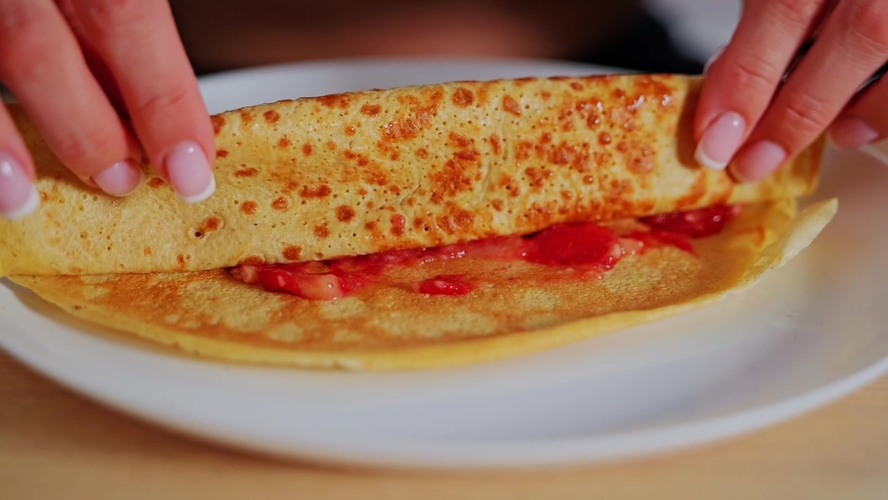 Fragole dolci sparse su una crêpe dorata creano una deliziosa prelibatezza per la colazione.