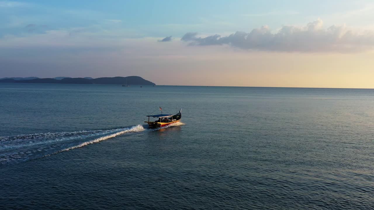 paisaje marino exótico, un dron de tiro aéreo cinematográfico vuela alrededor de un barco de pesca tradicional navegando en el mar, fuera y a punto de atrapar algunos peces salvajes en la hora dorada del atardecer