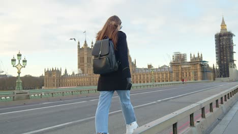 a girl tourist with backpack walking on london empty streets in lockdown.