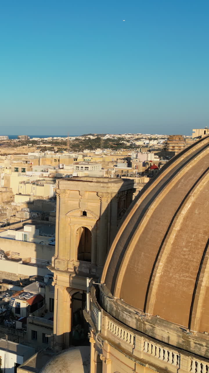 Aerial drone view of the walled city of Valletta, Malta, surrounded by the Mediterranean sea in daylight. Vertical vertical