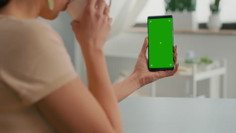 Business-woman-browsing-on-internet-using-mock-up-green-screen-chroma-key-smartphone