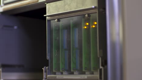 close-up of hands installing a circuit board into a server rack, focused on technology maintenance