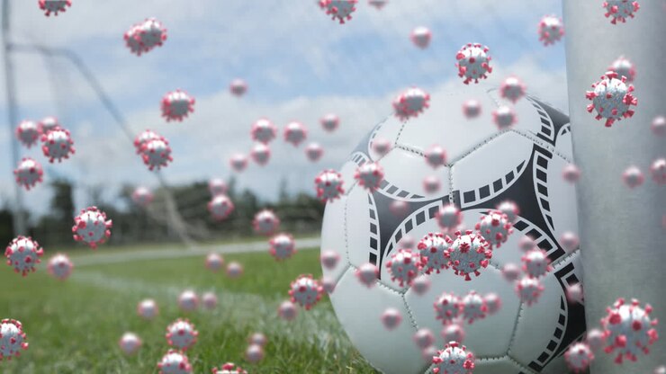 Cellule Covid-19 contro un pallone da calcio su un campo sportivo
