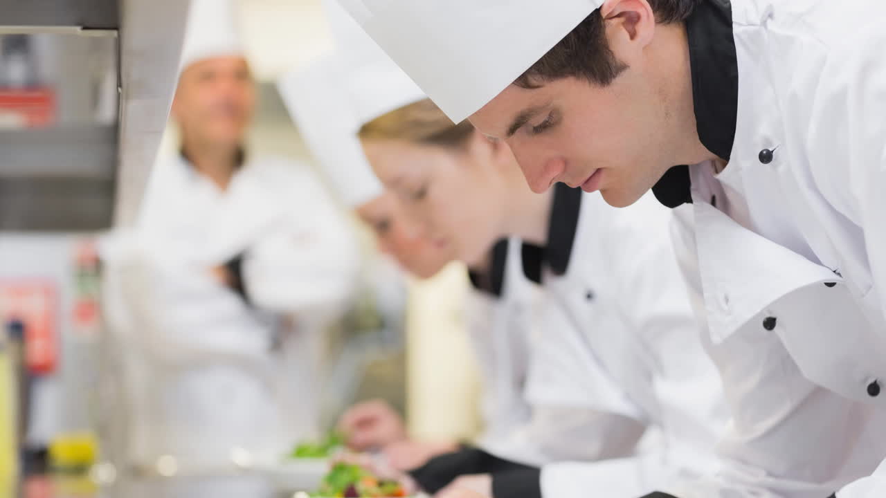 joven chef caucásico enfocado preparando comida en una cocina profesional