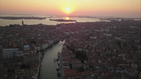 aerial shot flying towards sunrise over canal grande, venice, italy