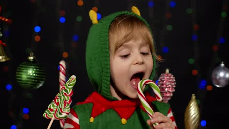 niña niña en la navidad elfo santa claus disfraz de ayudante lamer dulces piruleta caramelo dulces