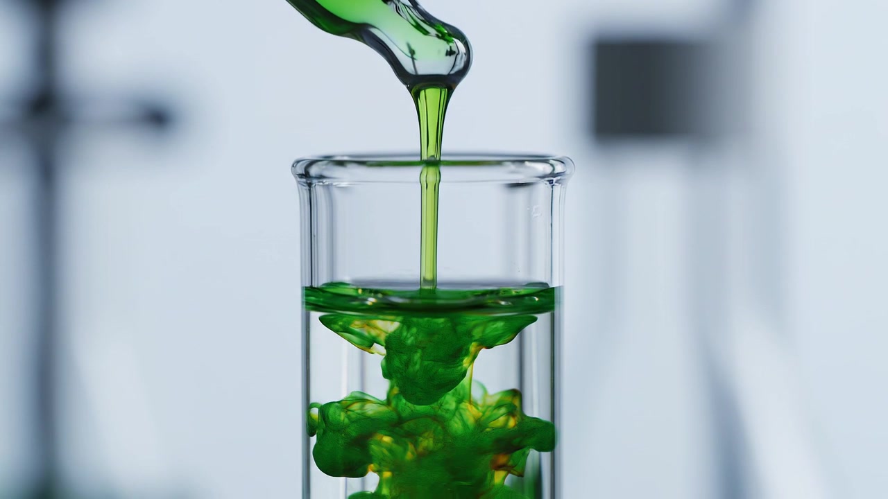 Green liquid dripping from pipette into glass test tube