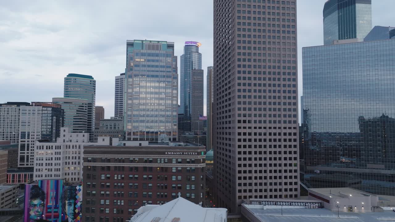 Aerial footage of downtown Minneapolis skyline at dusk with city buildings glowing.